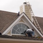 roofer making repairs around window and chimney